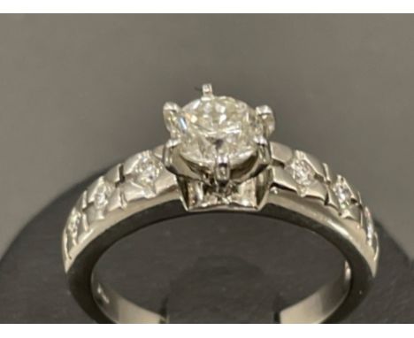 Ladies 18ct white gold diamond solitaire ring. Comprising of a Round brilliant cut diamond with 3 diamonds on each shoulder. 