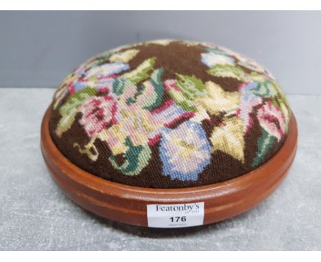 A circular footstool with woolwork cushion 26cm diameter.