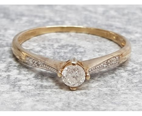 Ladies 9ct yellow gold diamond solitaire ring, featuring a round brilliant cut diamond set in a claw setting with 2 diamonds 