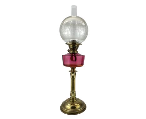 19th/ early 20th century brass oil lamp with cranberry glass reservoir, globular frosted glass shade and an Arts & Crafts sty