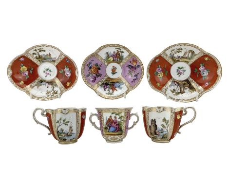 Pair of Meissen cabinet cups and saucers of lobed oval design decorated with coastal scenes, flower heads etc on an ochre gro