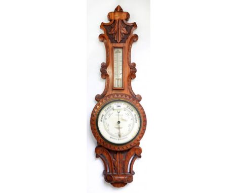 A CARVED OAK ANEROID BAROMETER BY T. ARMSTRONG  OF MANCHESTER, 71CM H
