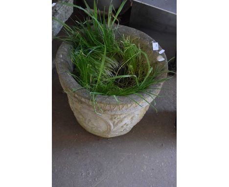 A concrete planter with moulded floral decoration