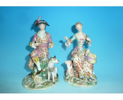 A pair of 19th century figures in the Chelsea manner depicting a couple in 18th century costume, the man seated with a dog, t