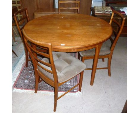 A 1970's teak circular extending dining table by Mackintosh with 4 similar ladder back chairs