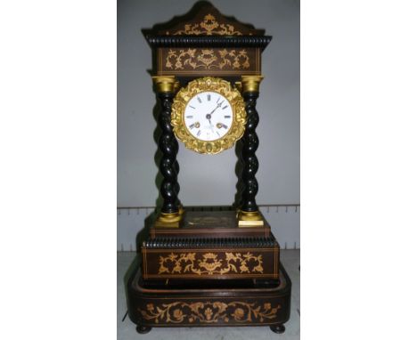 A 19th century ebonised portico clock with extensive marquetry work inlay, ormolu mounted barley twist columns and bezel, orn