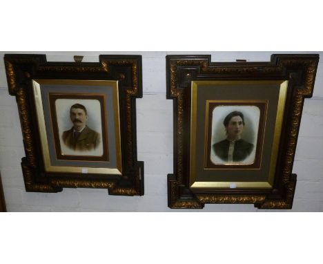 A pair of Edwardian heightened half-length portrait photographs on opaque glass panels, of a lady and a gentleman, in ornate 
