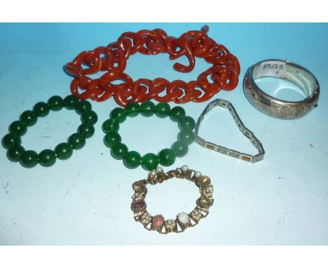 A silver bangle; gem set bracelets; 2 jade coloured bracelets; a coral coloured necklace