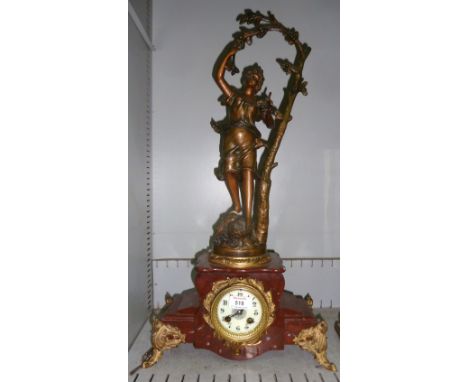 A French red marble mantel clock surmounted by a gilt metal female figure with branch, on 4 cast feet, with French drum movem