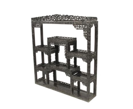  A 19th century Chinese carved and pierced ebony open display shelf, with a detachable cornice above a scrolling foliage deco