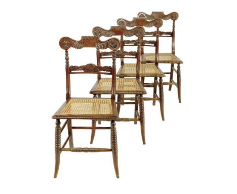 λ A set of four George IV simulated rosewood side chairs, each with a gadrooned and foliate carved back above a cane seat and