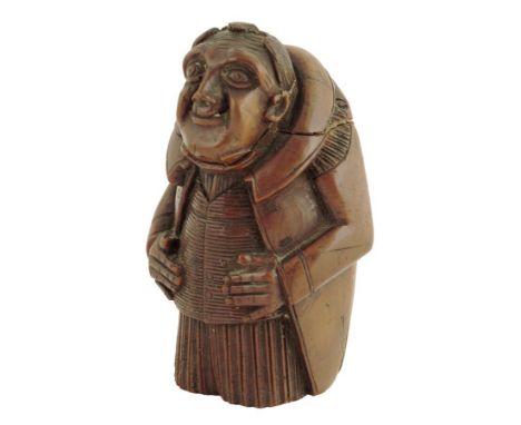  An early 19th century French carved coquilla nut figural snuff box, in the form of a hunchback, 6.3cm high.