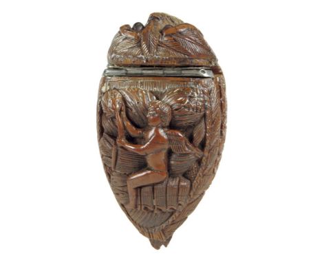  An early 19th century French carved coquilla snuff box, with a bugbear end, the hinged lid carved with a winged cherub and p