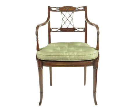 An Edwardian mahogany open armchair, the lattice back carved with a patera and husks, with a silk squab cushion and a cane s
