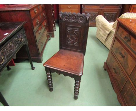 Circa 1860 a carved oak hall chair on bobbin turned fore legs 