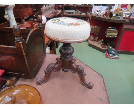 A Victorian mahogany revolving piano stool with carved cabriole legs, needlepoint tapestry seat 