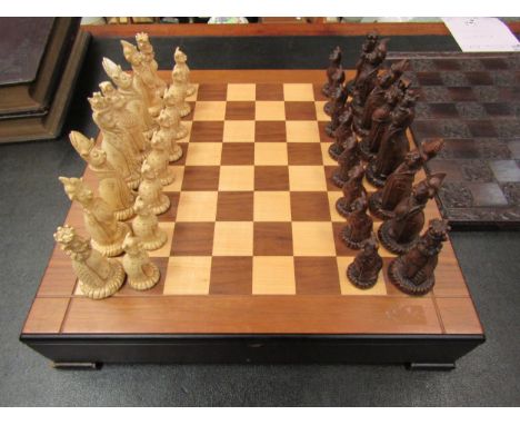 A Tudor rose chessboard and another chess set with Cheshire cat themed pieces 