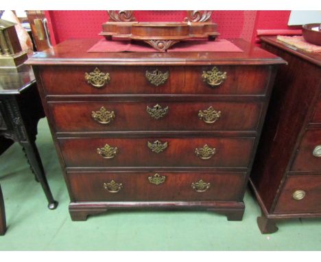 A George III flame mahogany chest of four graduating drawers with pierced brass back plate and swan neck handles over bracket