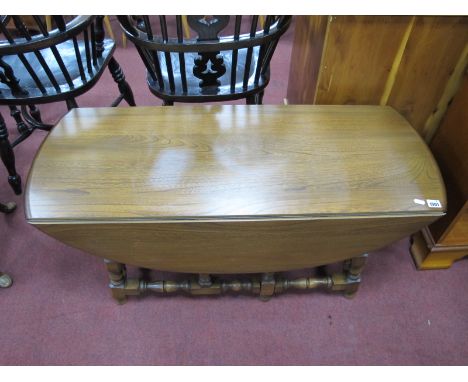 An Ercol Coffee Table, with drop leaves, on turned and block supports.