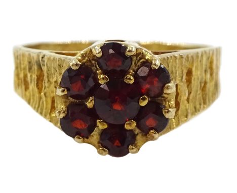 9ct gold garnet flower head cluster ring, with textured and pierced shoulders by Slade &amp; Kempton, London 1978Condition Re