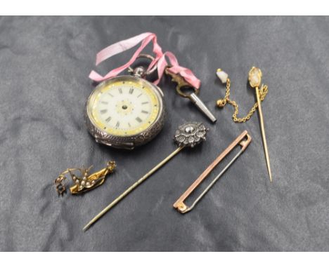 A small continental silver key wound pocket watch having a Roman numeral dial on a gilt decorated enamel face in an extensive