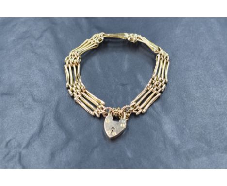 A 9ct gold four bar gate bracelet, having a heart padlock clasp with safety chain, marked 9ct, 10g