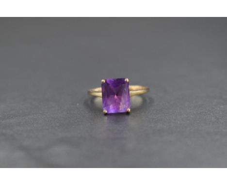 A 9ct gold amethyst set ring, the emerald cut amethyst being approx 2ct in a four claw mount on a 9ct gold loop, size R &amp;