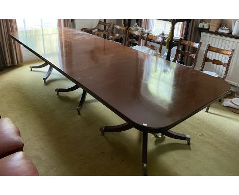 A triple pillar mahogany extending dining table in George III style, rectangular with rounded corners, on quadruped swept leg