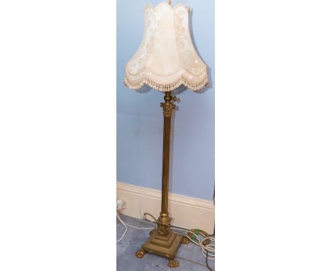 A late Victorian/Edwardian brass Corinthian column adjustable standard lamp with stepped base and lion paw feet 