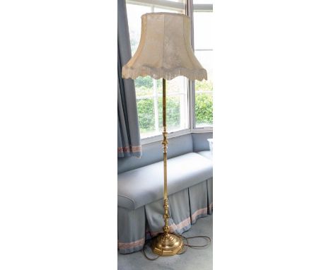 A late Victorian/Edwardian decorative brass adjustable standard lamp with domed and fluted base: another slender example, mod
