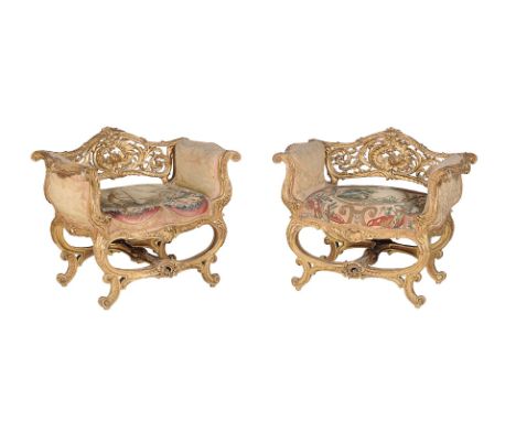 A pair of French carved giltwood and composition window seats, late 19th century, in the rocaille style, the elaborate pierce