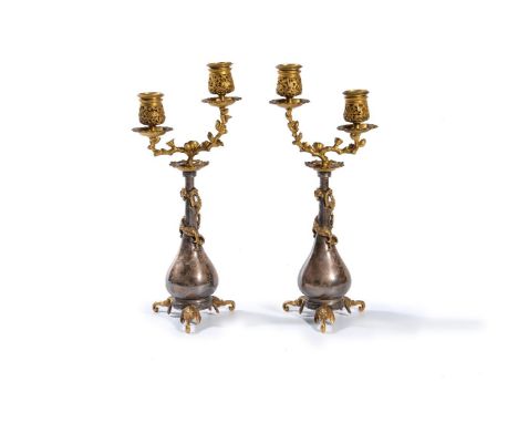 ‡A pair of gilt and silvered metal twin light candelabra in Chinoiserie taste to designs by Edouard Lièvre, likely by Ferdina