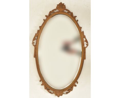 A vintage mid century gilt framed hanging mirror. The mirror of oval form having acanthus pierced motifs surround, with flora
