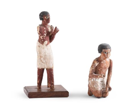 TWO EGYPTIAN POLYCHROME PAINTED WOOD FIGURES  MIDDLE KINGDOM, CIRCA 2025-1700 B.C.  Both with much of the polychrome decorati