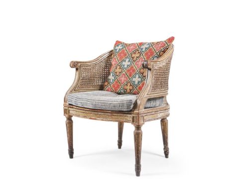 A LOUIS XVI PAINTED WALNUT BERGERE ARMCHAIR  LATE 18TH CENTURY  The caned seat with a natural linen buttoned squab  86cm high