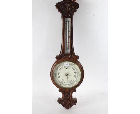 oak cased wheel barometer with shell decoration to the top together with a Smiths Arts and Crafts style oak cased mantle cloc