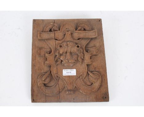 An 19th Century carved oak panel, the square panel designed with a lions head to the centre with a crest behind, 25cm high 21