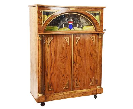 An original Seeburg KT Nickelodeon. Coin-operated. Oak cabinet with leaded glass (eagle art glass) panel. Features - Tambouri