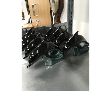 Eight Poole Pottery dolphins.