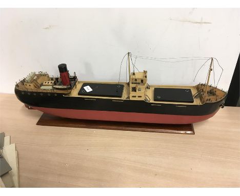 A 1950 design model of a cargo freight ship in black and red