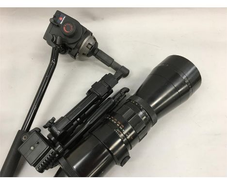 A large Pentacon Camera lense with a small tripod and half a tripod.