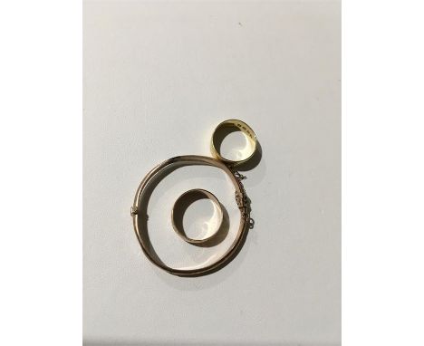 An 18ct yellow gold wedding band (4.4 grams) with a 9ct rose gold child's bangle and a 9 ct rose gold wedding band (combined 