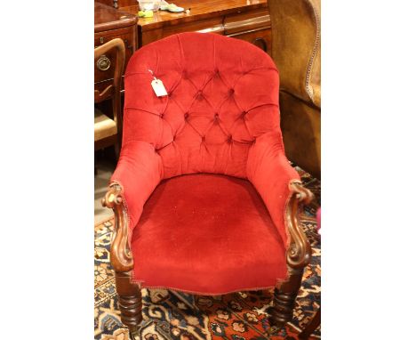 A 19th century carved mahogany spoon back armchair, button upholstered in a red velour, on turned and castored supports 