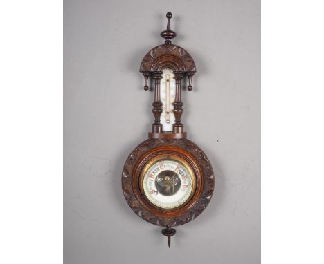 A late 19th century carved and turned mahogany cased aneroid barometer and thermometer, 18" long 