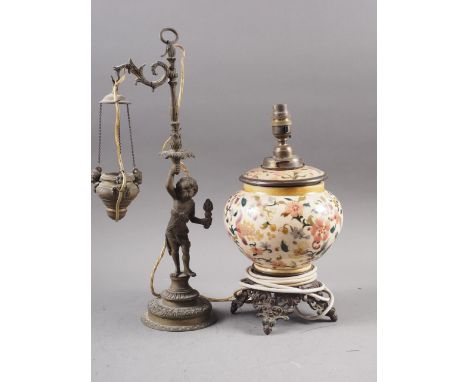 A 19th century oil lamp, formed as a cherub holding a torch, now converted to electricity, 18" high, and a Zsolnay oil lamp w