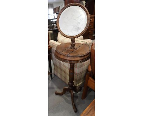 An early 20th century walnut shaving stand with tilting mirror, on tripod splay support, 54" high x 17" dia 