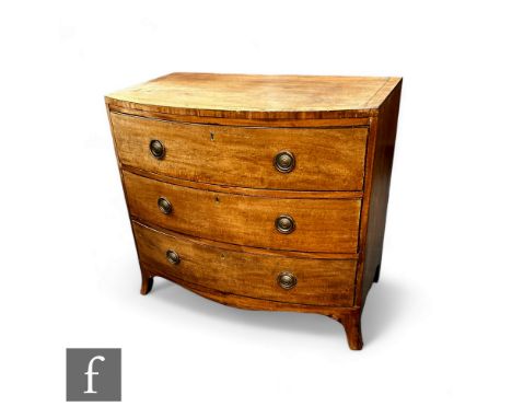 A mahogany George III bow front chest of drawers, the plank top over three long drawers, with brass ring handles, over splaye