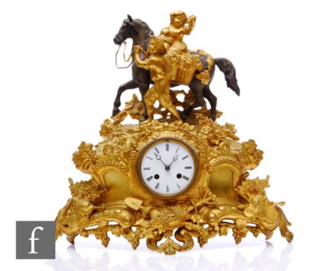 A French 19th Century Japy Freres gilt metal mantle clock, cast with fruiting vines, and surmounted by a figure on horseback,