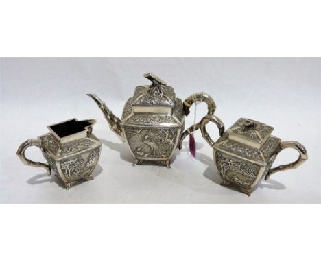 A Chinese export silver tea service comprising teapot, sucrier and milk jug, with chased panels of auspicious cranes, bamboo 