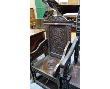 A James II joined oak wainscote elbow chair, the fielded back carved with two birds and scrolled foliage. The seat adapted as